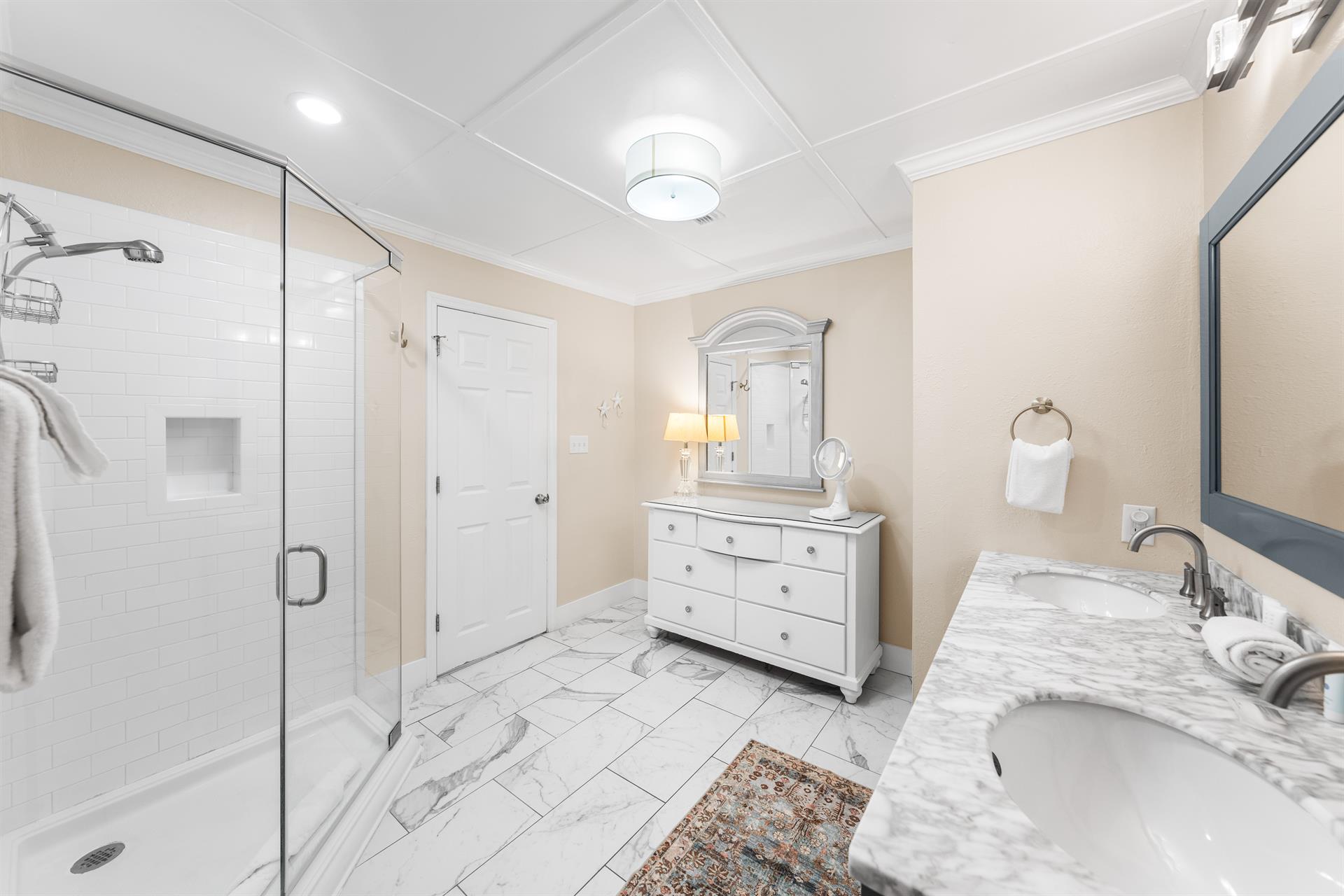 Living the dream with a walkin shower, double sinks, and a makeup stationvanity. Plus, the toilet gets its own room—privacy goals.