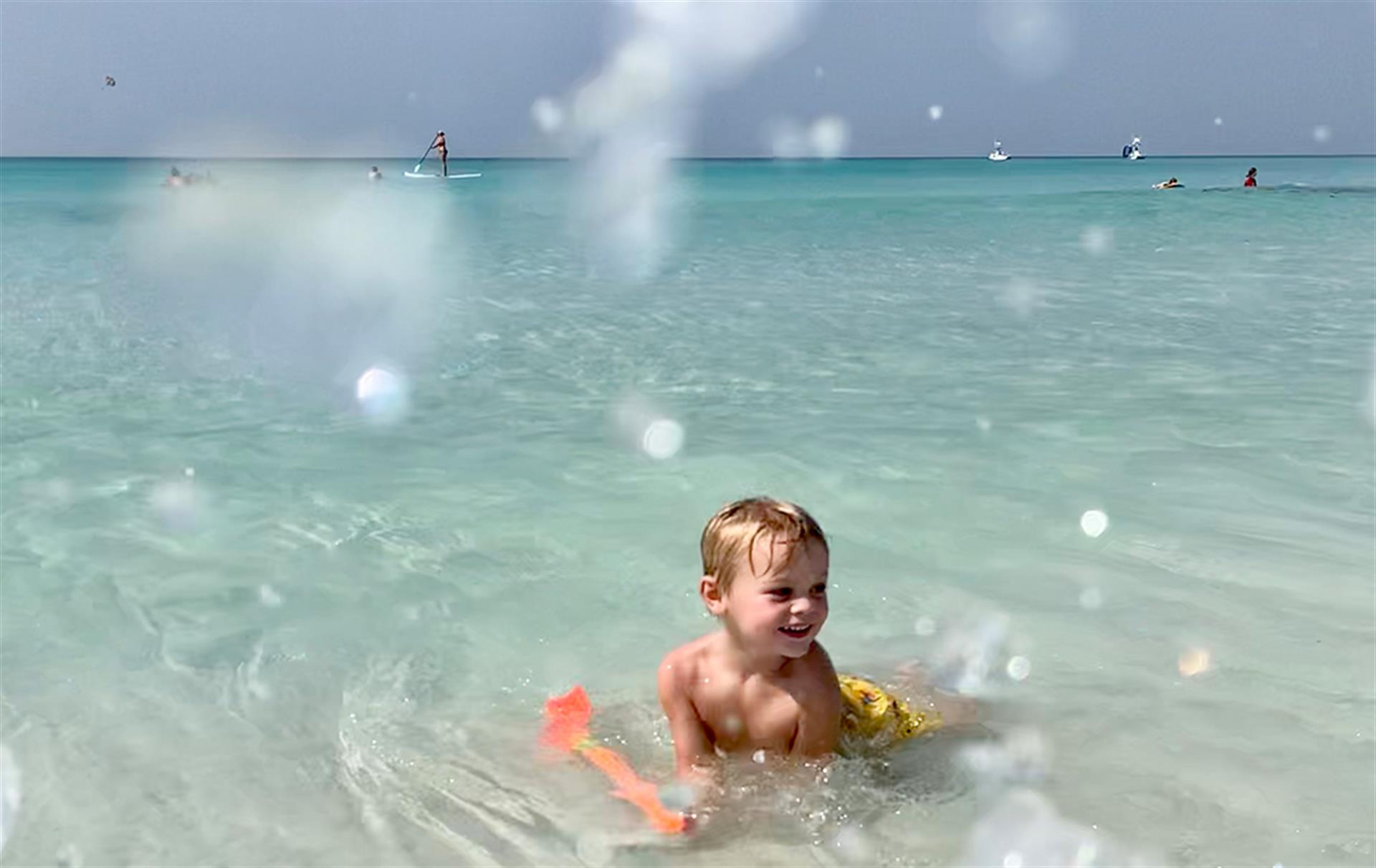 toddler playing int he waves at a destin beach