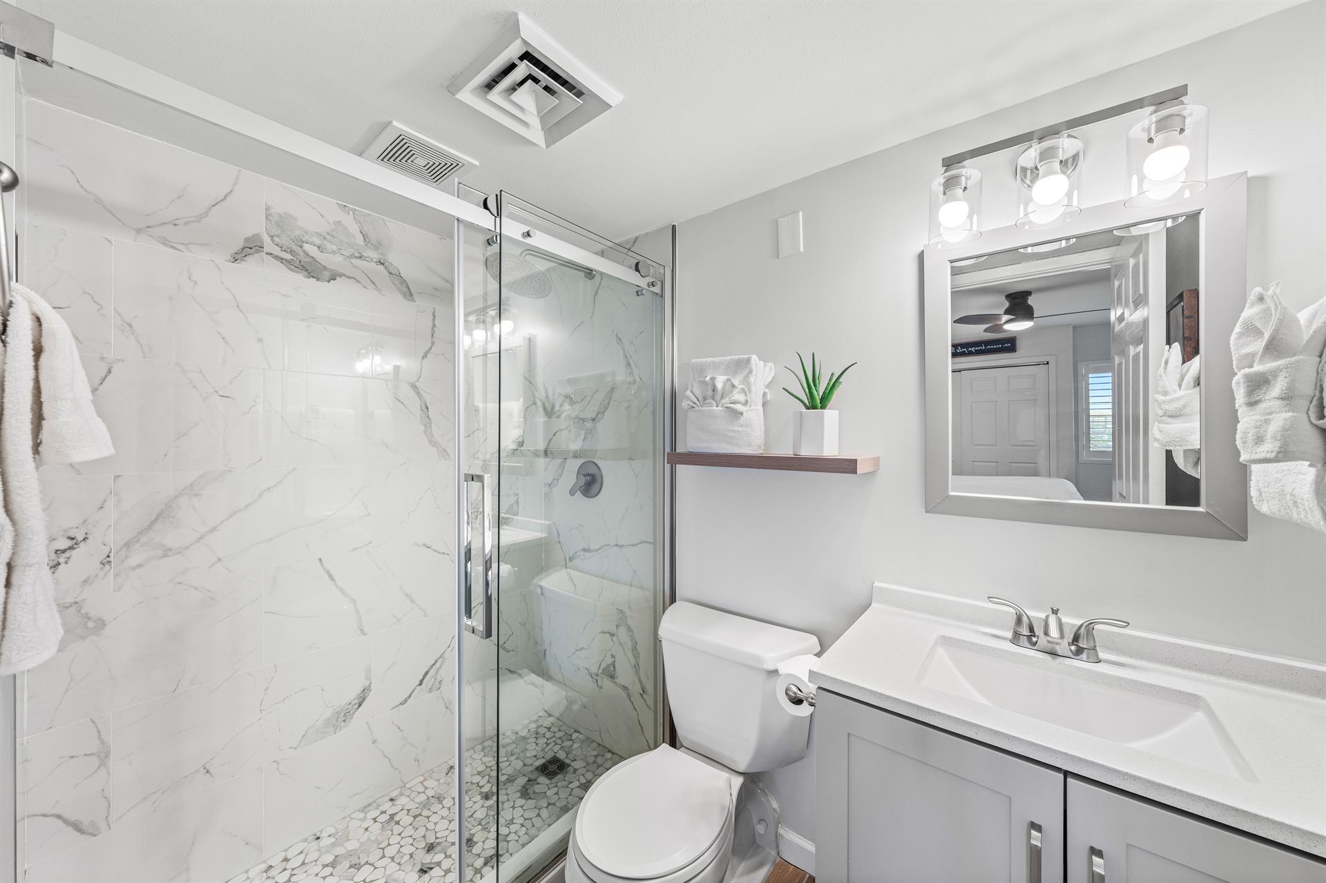 Newly renovated master bathroom with sleek vanity and spacious w