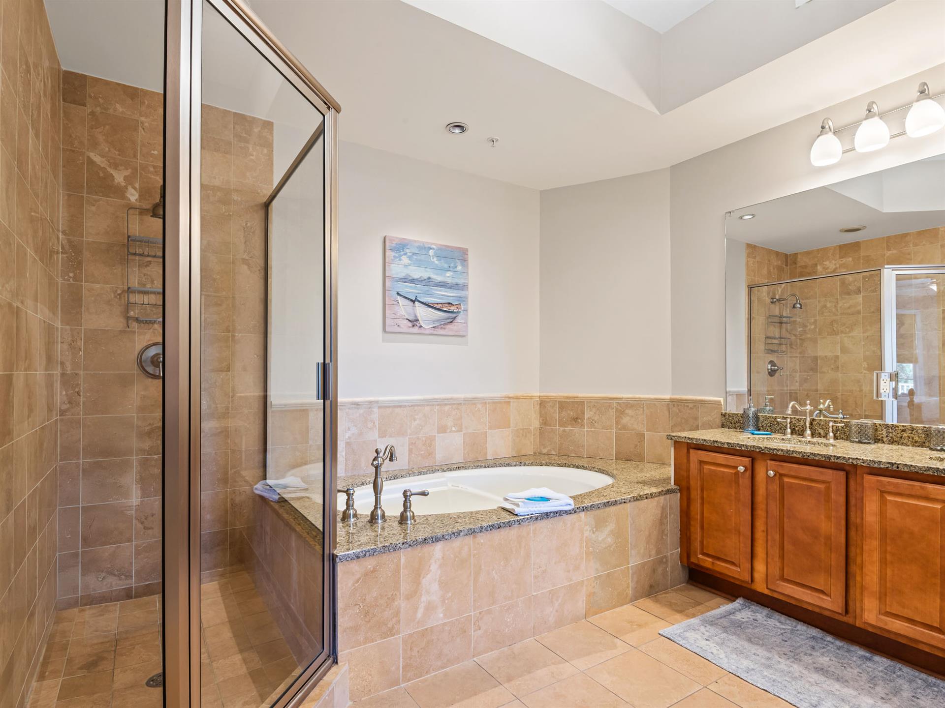 Bathroom 2 Indulge in your private spalike retreat with a luxurious soaking tub and separate glass shower, perfect for unwinding after beach adventures.