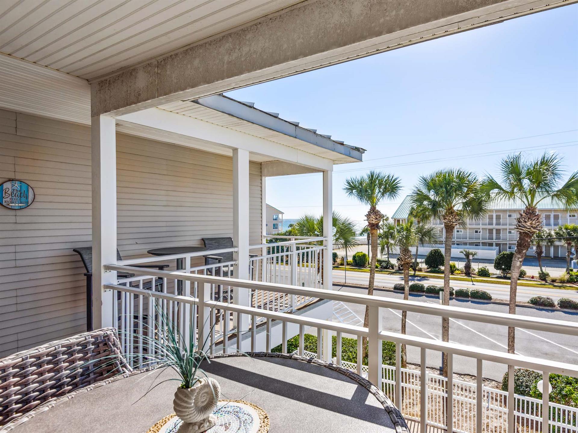 Private balcony that overlooks tropical palms and nearby coastal buildings, perfect for morning coffee or evening relaxation.