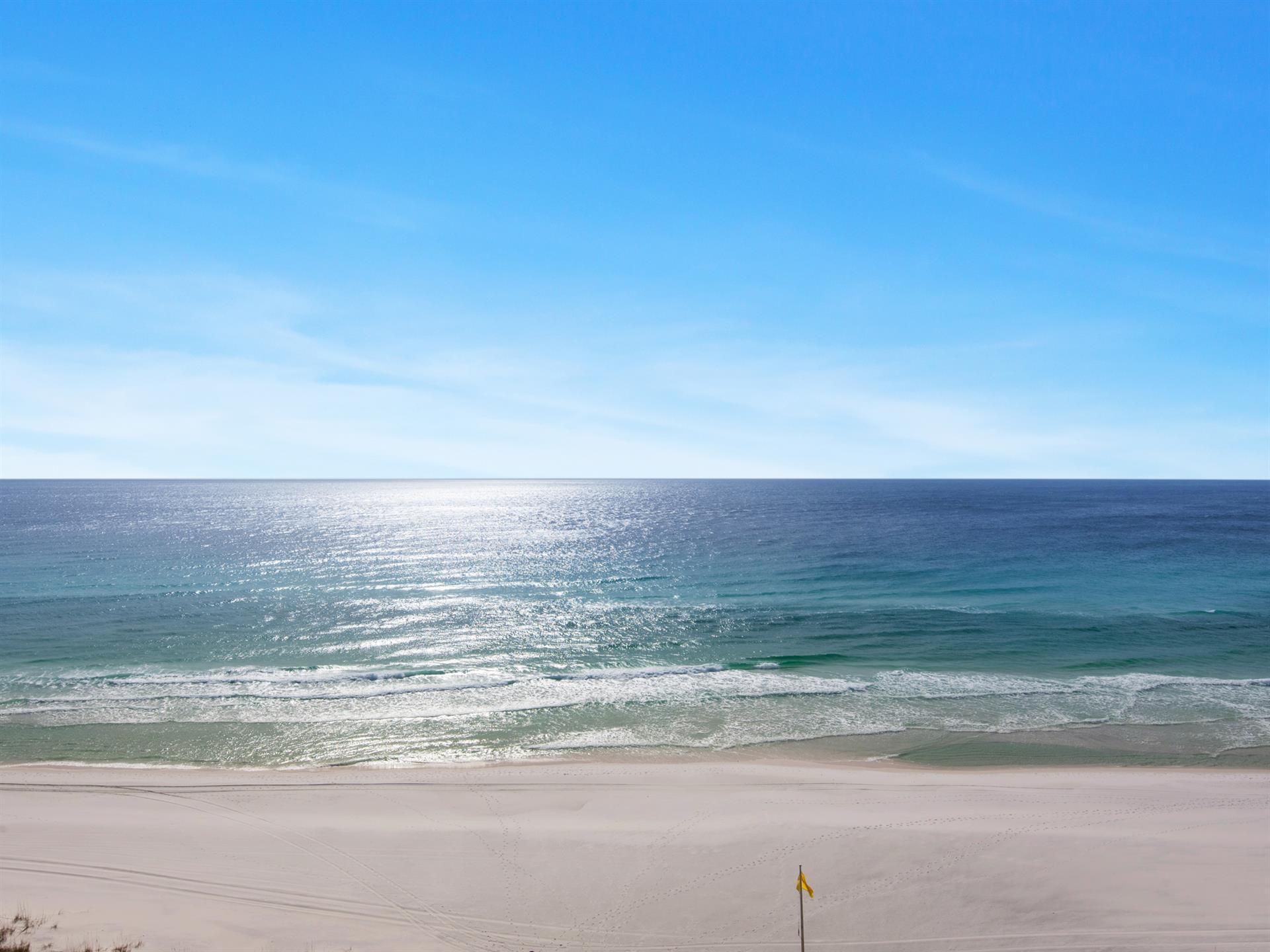 Pristine beach with crystalclear turquoise waters and soft white sand stretches endlessly under brilliant blue skies.