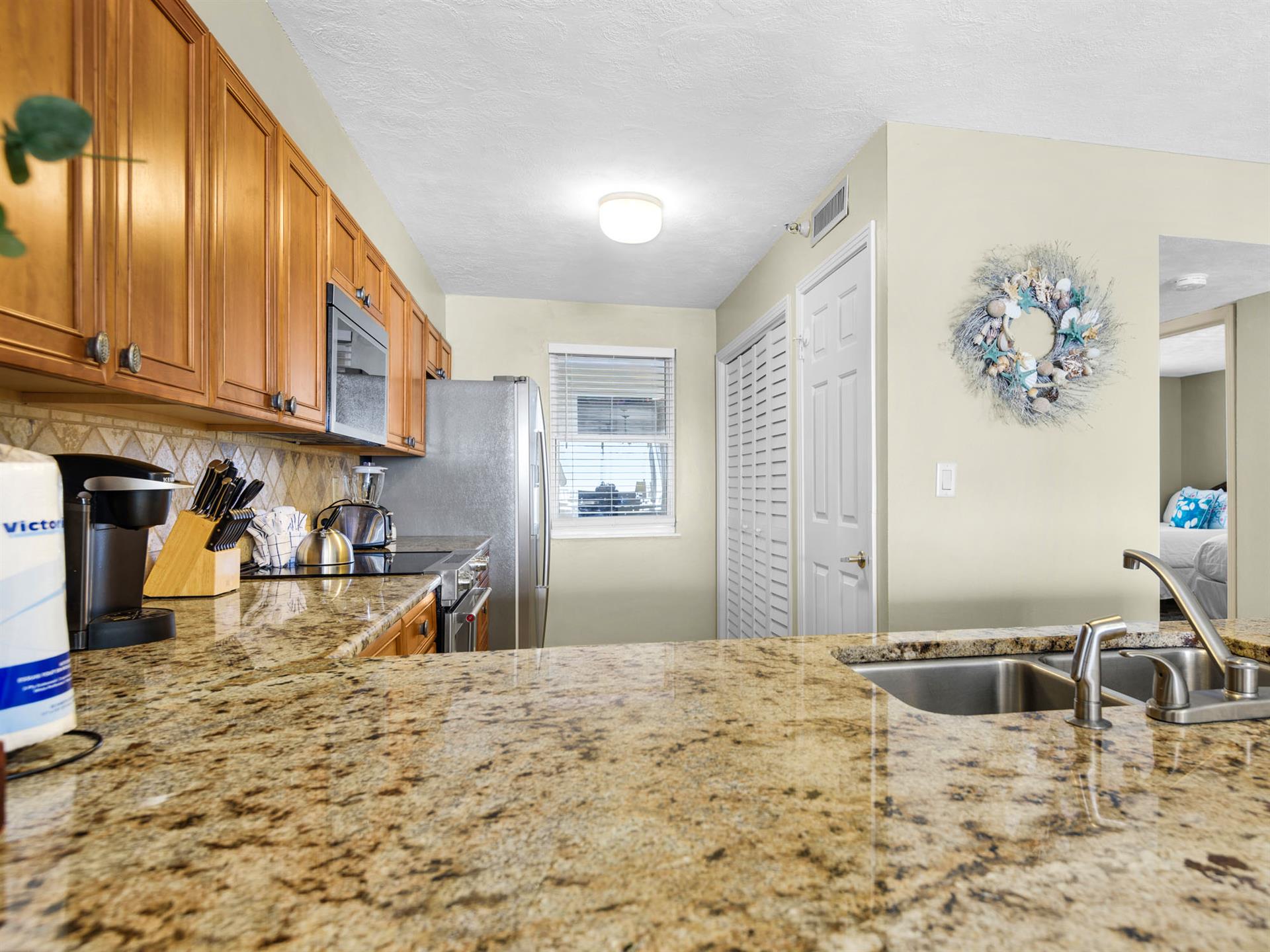 Your fully equipped kitchen features granite countertops, stainless steel appliances, and warm wood cabinetry perfect for preparing memorable meals.