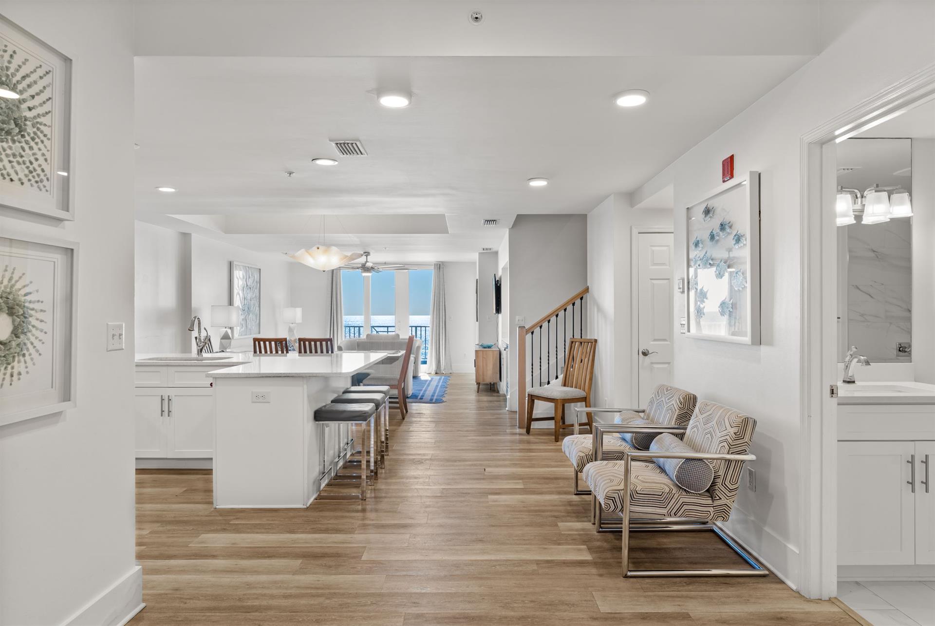 Relax in your spacious openconcept living space with modern coastal decor, quartz kitchen countertops, and stunning gulf views through floortoceiling windows.