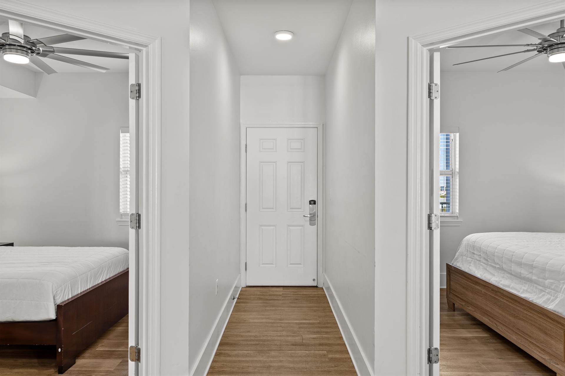 Your private hallway connects two comfortable bedrooms, each with ceiling fans and city views for a restful stay.