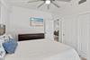 Drift off in your bright 2nd floor queen bedroom with coastal charm—soft linens, ocean artwork, and a ceiling fan for perfect comfort.