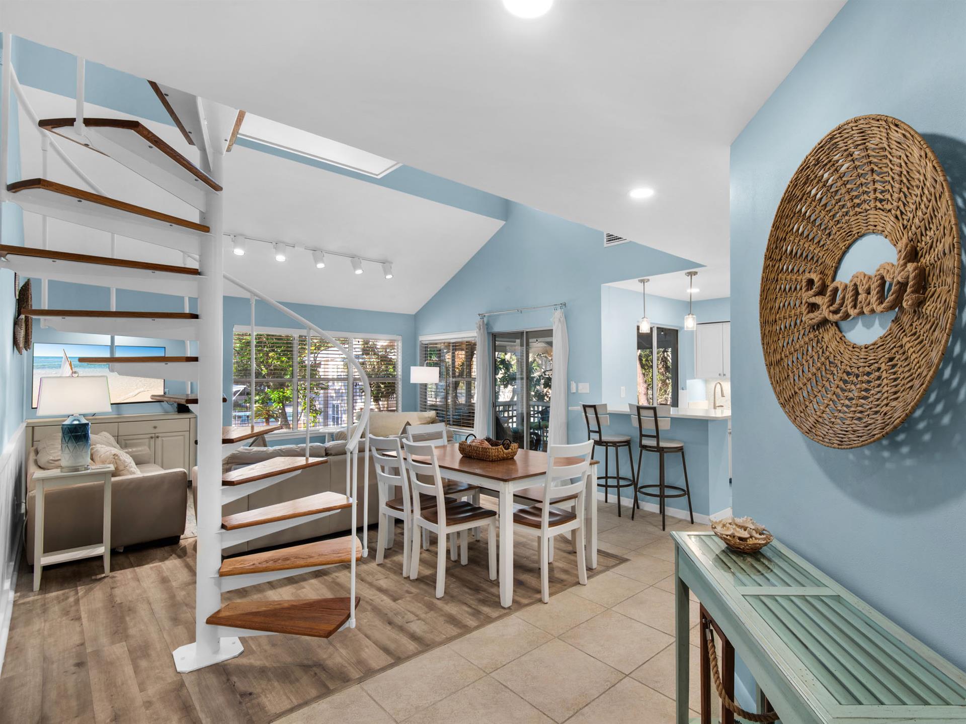 Your coastalinspired dining area features soothing blue walls, natural light streaming through skylights, and a welcoming table for memorable meals with loved ones.