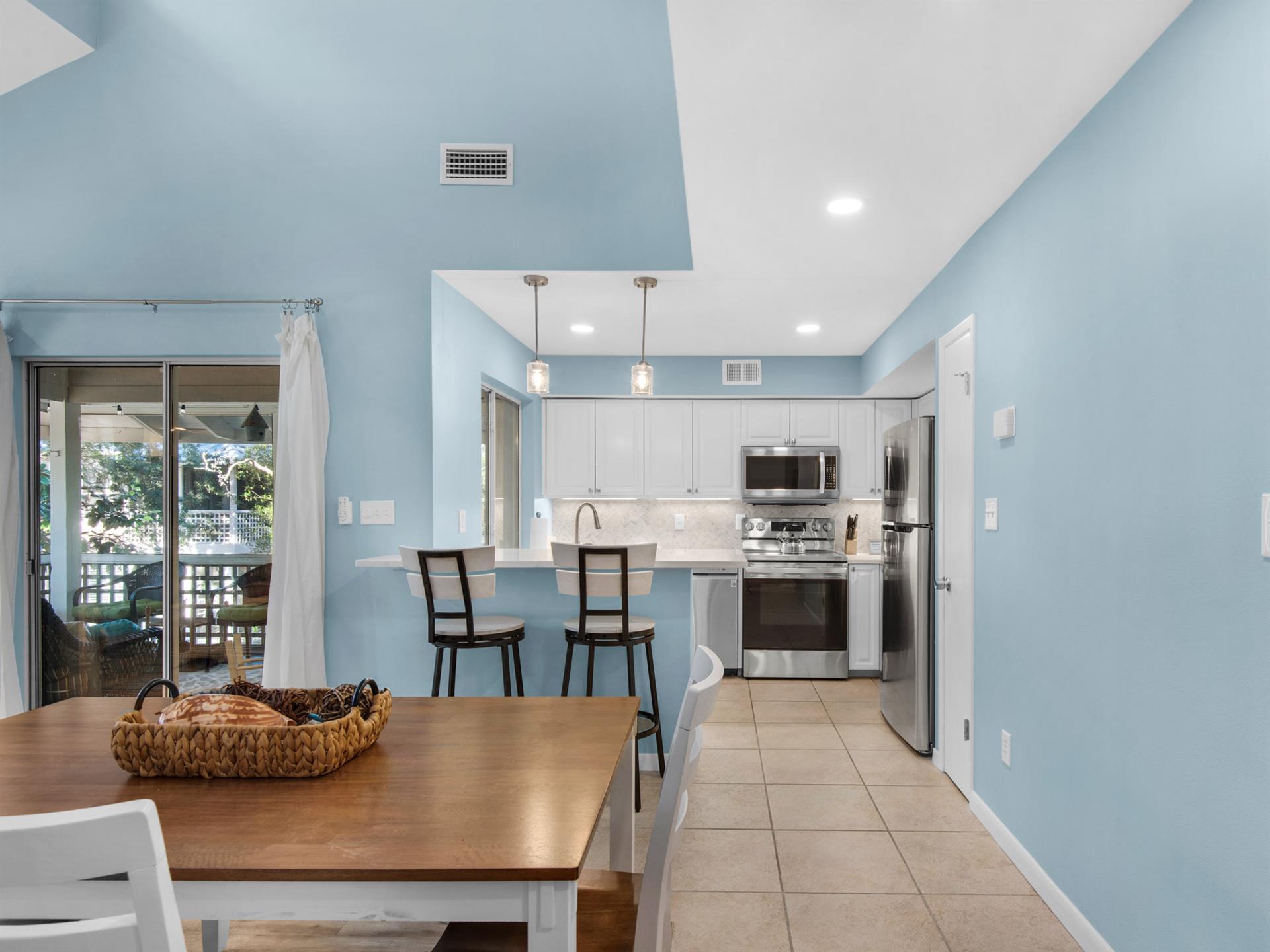 Your bright, airy kitchen flows seamlessly into the dining area, where ocean breezes and natural light create the perfect space for morning coffee.