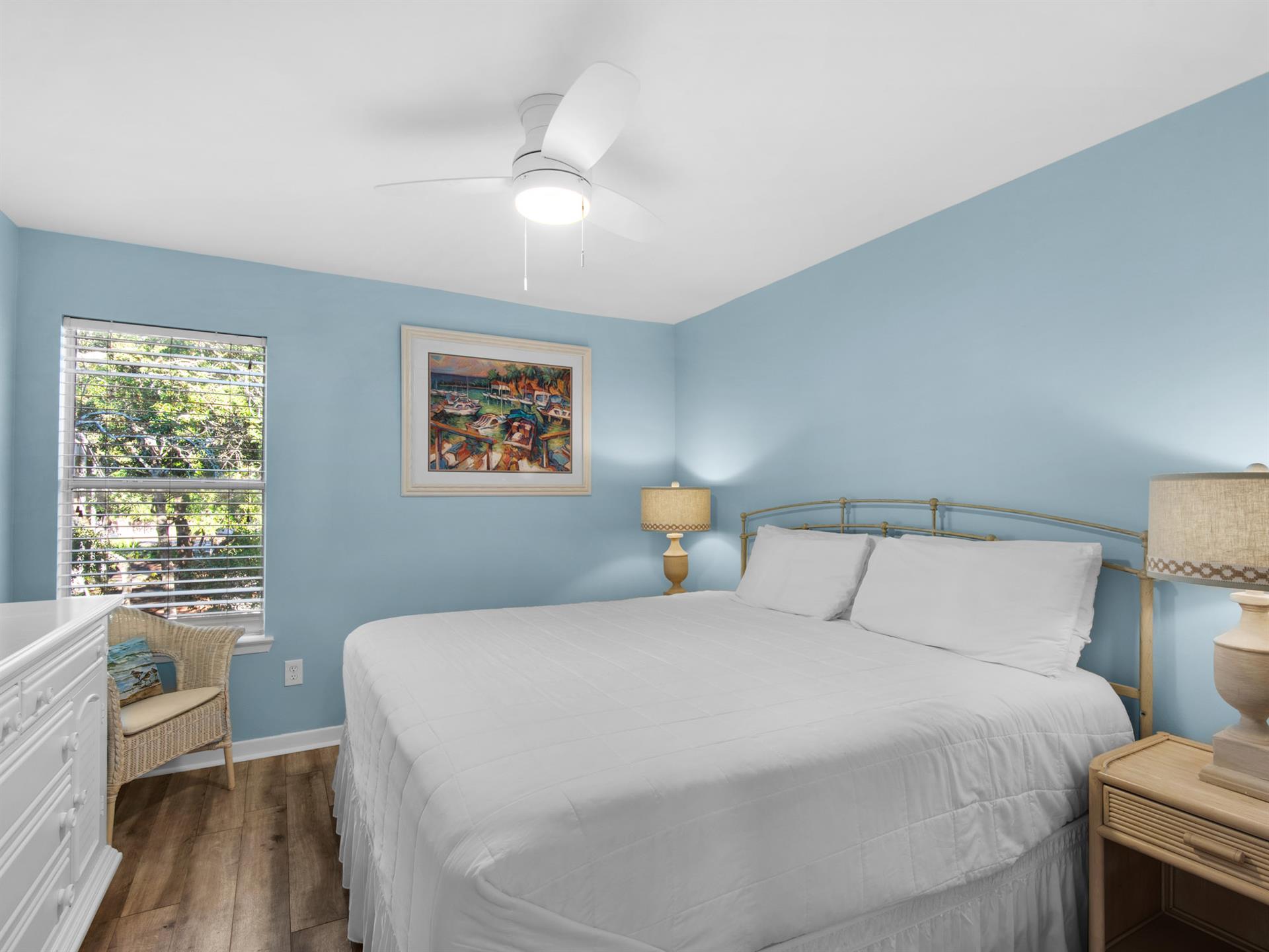 Drift off in your peaceful coastal bedroom, where soft blue walls and crisp white linens create the perfect seaside sanctuary.