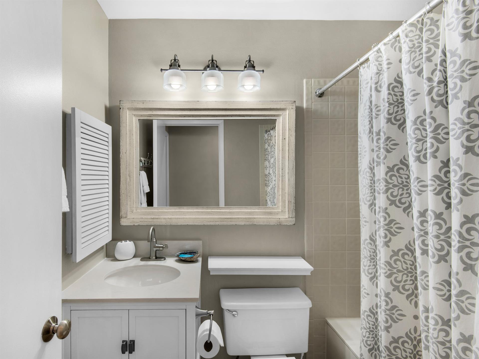 Your private bathroom features a relaxing soaking tub, elegant vanity, and charming coastalinspired decor for your comfort.