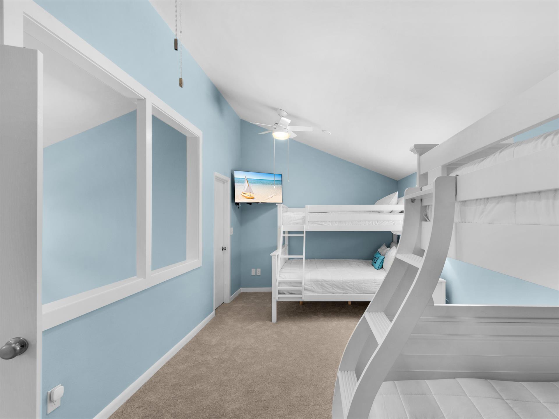 Your kids will love this cheerful bunk room with oceanblue walls and crisp white beds, complete with entertainment for cozy evenings.