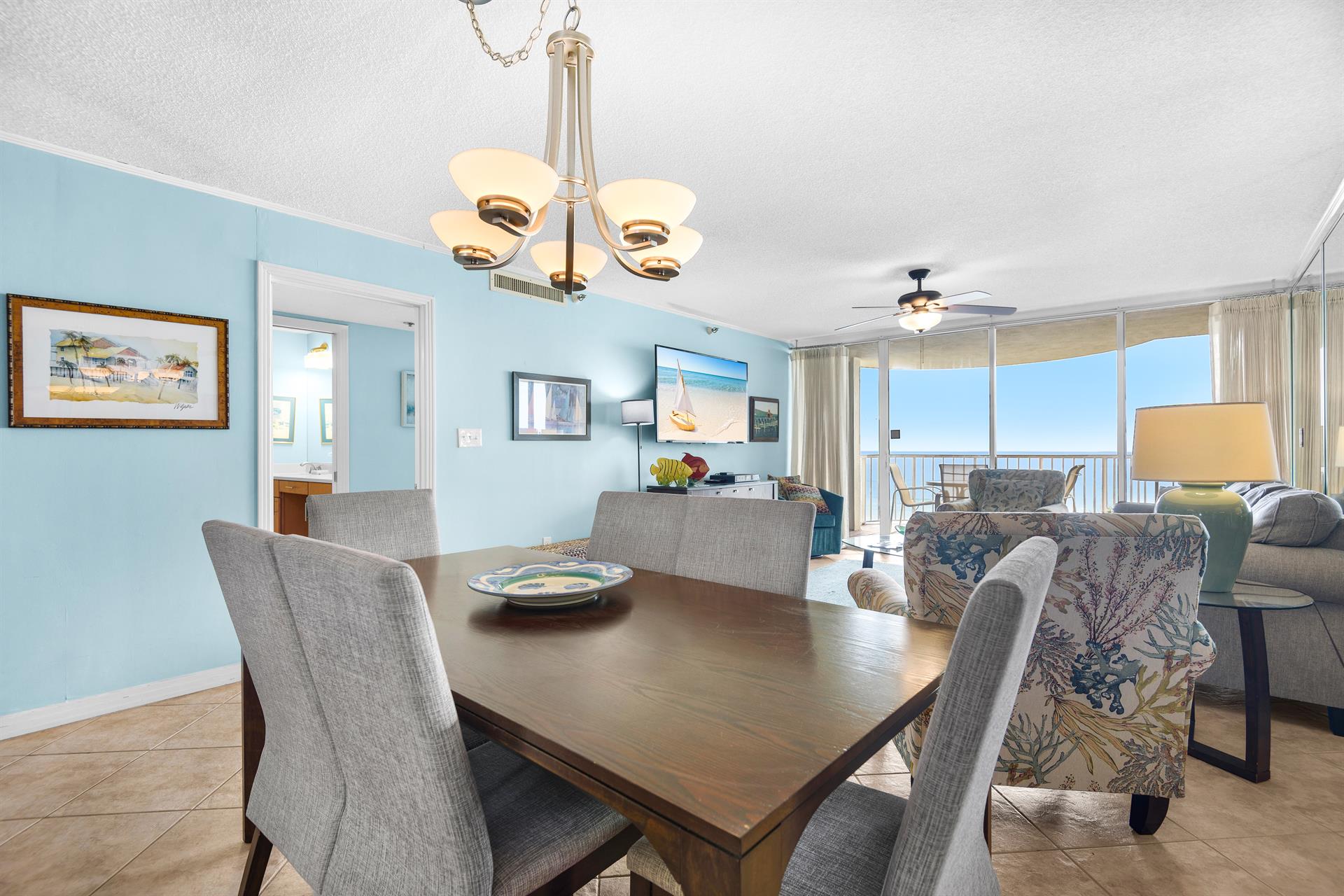 Gather around this elegant dining table where ocean views through floortoceiling windows create the perfect backdrop for your memorable meals together.