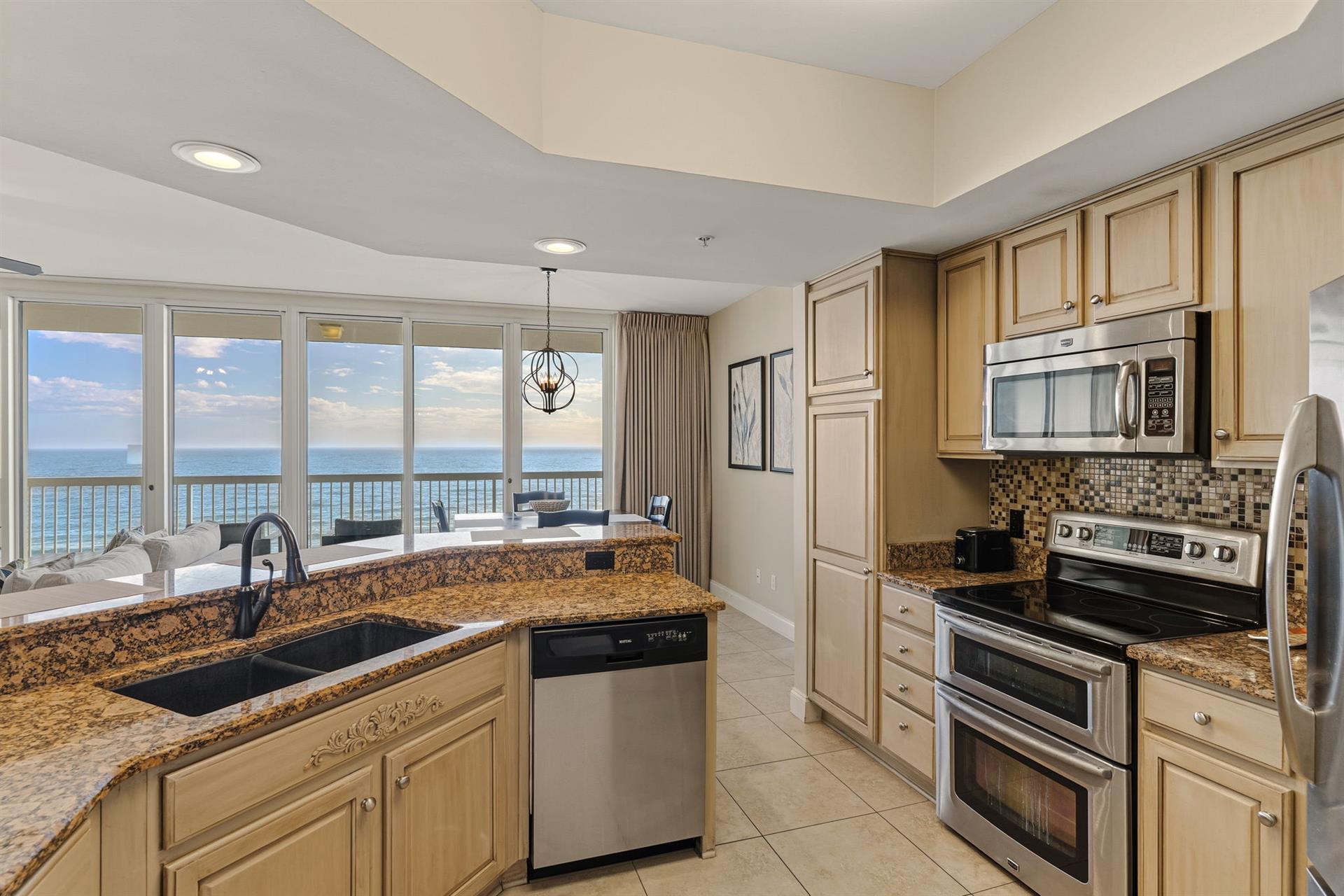 Your oceanfront kitchen invites culinary adventures with granite counters and breathtaking sea views stretching to the horizon.