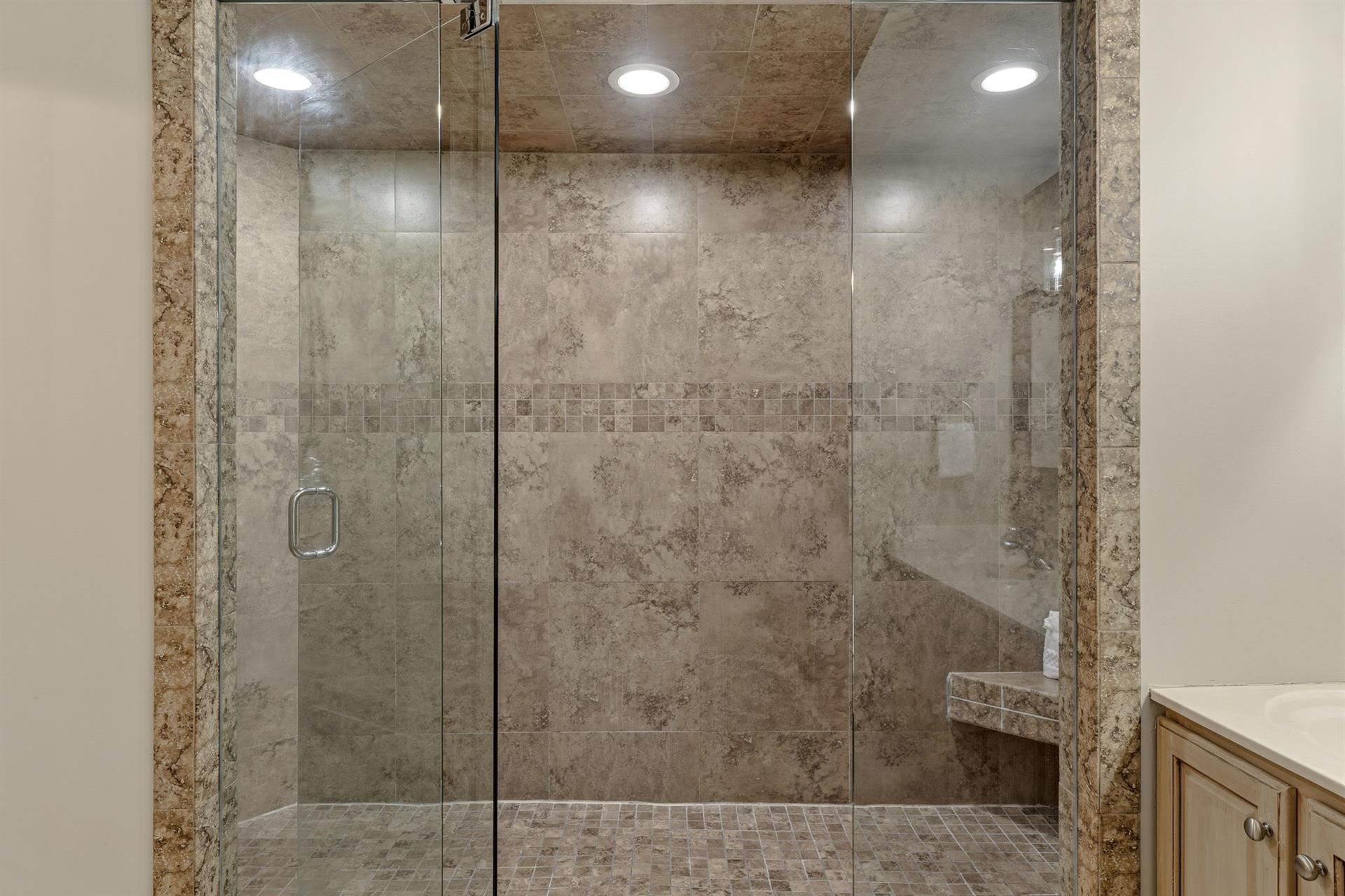 Bathroom1 features spalike shower sanctuary with luxurious stone tiles and elegant glass enclosure.