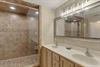 Bathroom 1 with dual sinks, granite counters, and spacious walkin shower with beautiful stone tile work awaits your relaxing retreat.