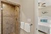 Bathroom 2 with a private spalike shower with natural stone tiles and modern fixtures, perfectly positioned near your peaceful bedroom retreat.