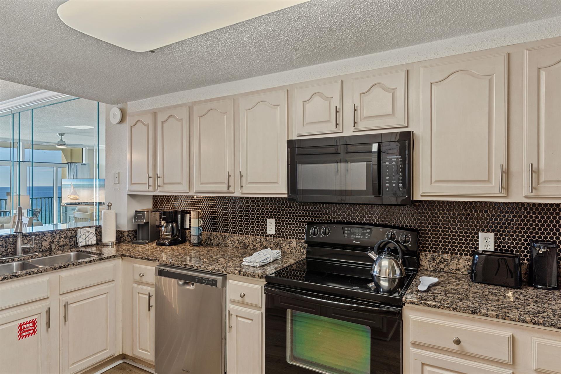 Your fully equipped kitchen features granite counters, stainless appliances, and stunning ocean views.