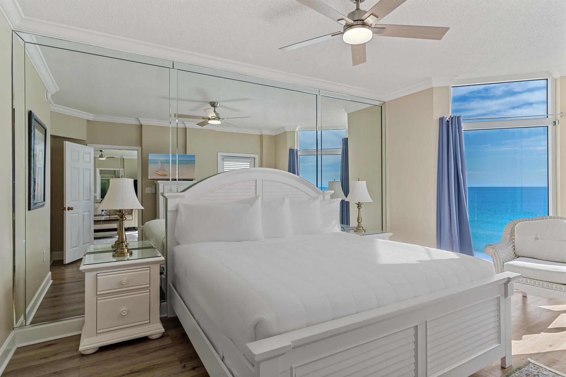 Bedroom 1 with stunning views, where crisp white linens meet coastal breezes through floortoceiling windows.