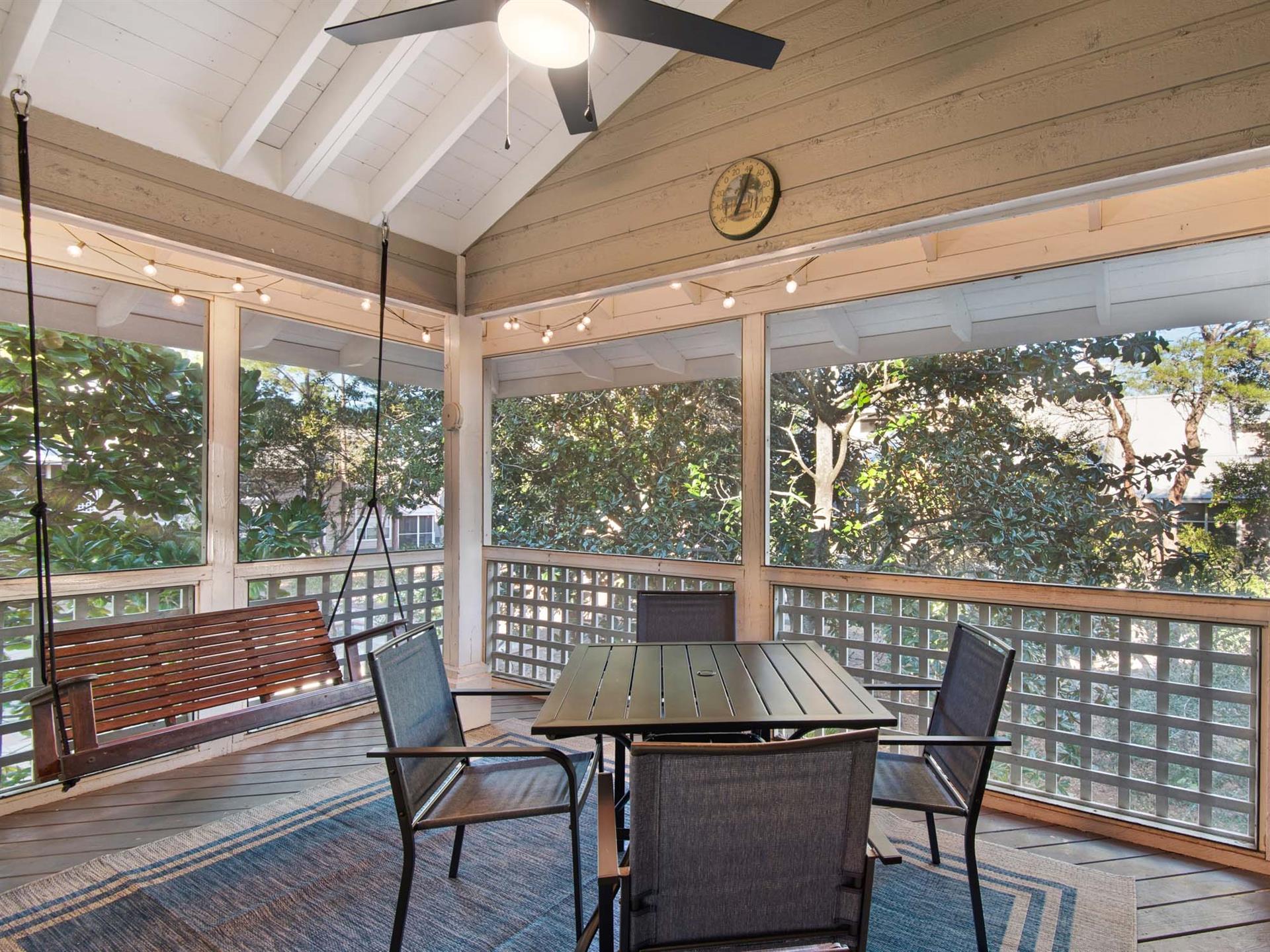 Your covered deck offers peaceful dining surrounded by lush greenery, with twinkling string lights creating perfect ambiance for morning coffee or evening meals.