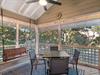 Your covered deck offers peaceful dining surrounded by lush greenery, with twinkling string lights creating perfect ambiance for morning coffee or evening meals.