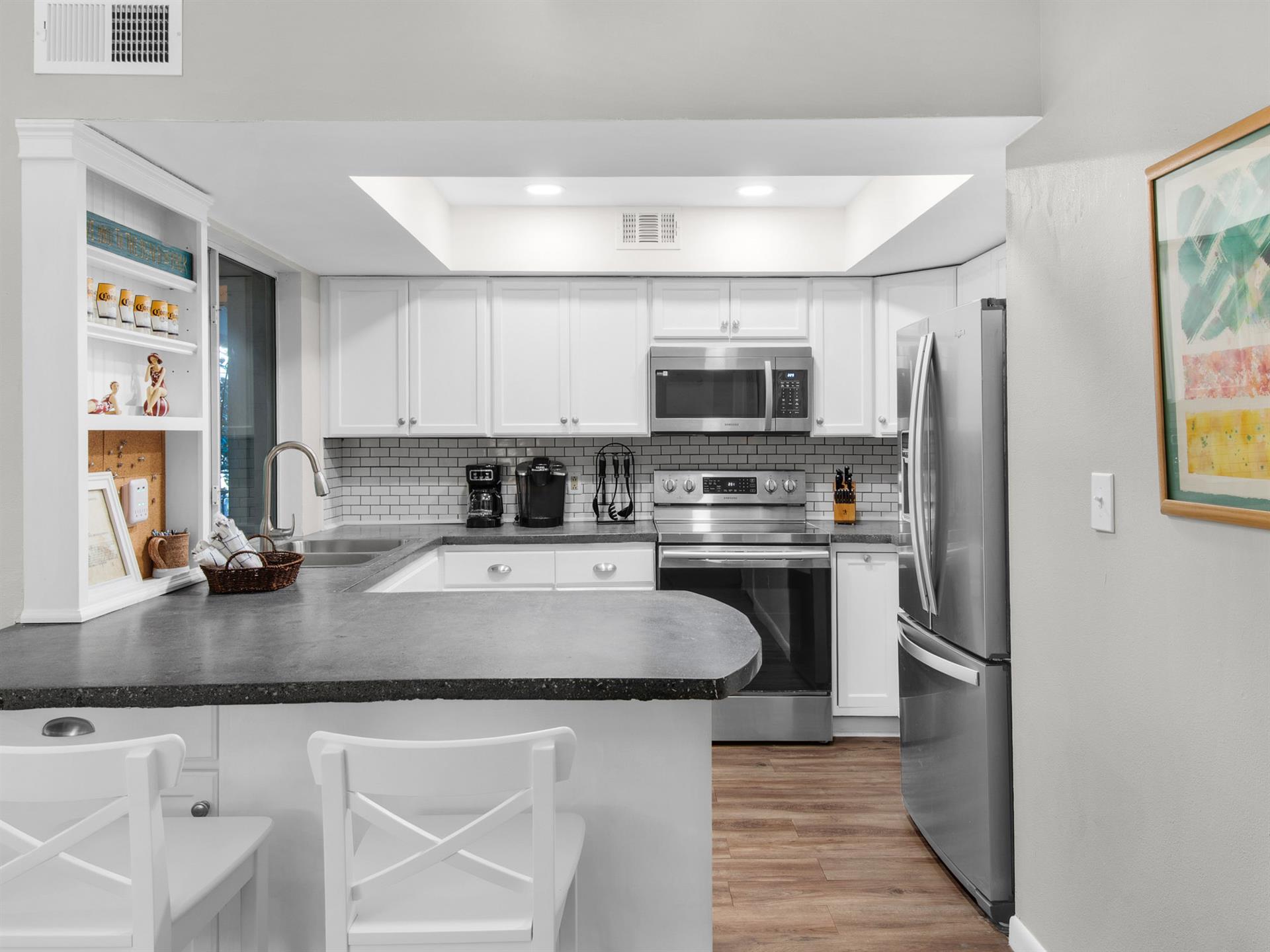 Your fully equipped kitchen invites culinary adventures with granite counters, stainless appliances, and charming subway tile backsplash.