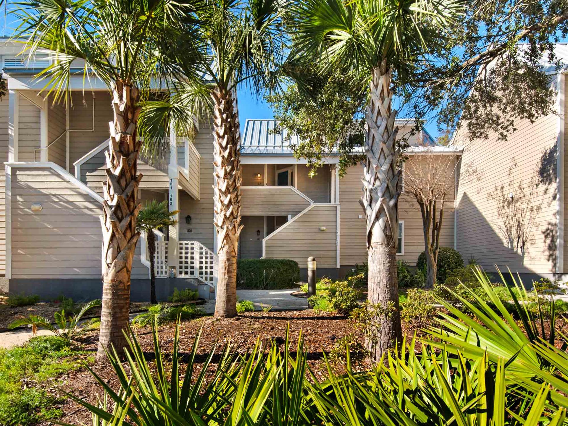 Modern coastal buildings nestled among swaying palm trees and tropical landscaping create a serene resort atmosphere.