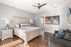 Bedroom 1 featuring a plush king bed, cozy seating area, and elegant coastal artwork that creates the perfect retreat.