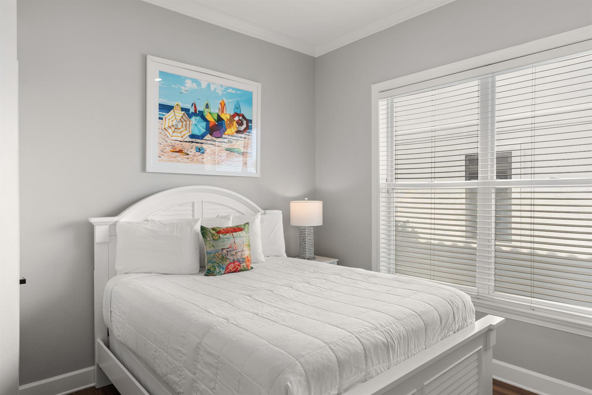 Drift off in the serene coastal bedroom, where soft gray walls and beachthemed artwork create the perfect retreat after a day of adventures.