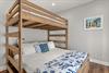 Sleep soundly in the cozy bunk bed with nauticalthemed linens and coastal artwork creating a charming retreat.