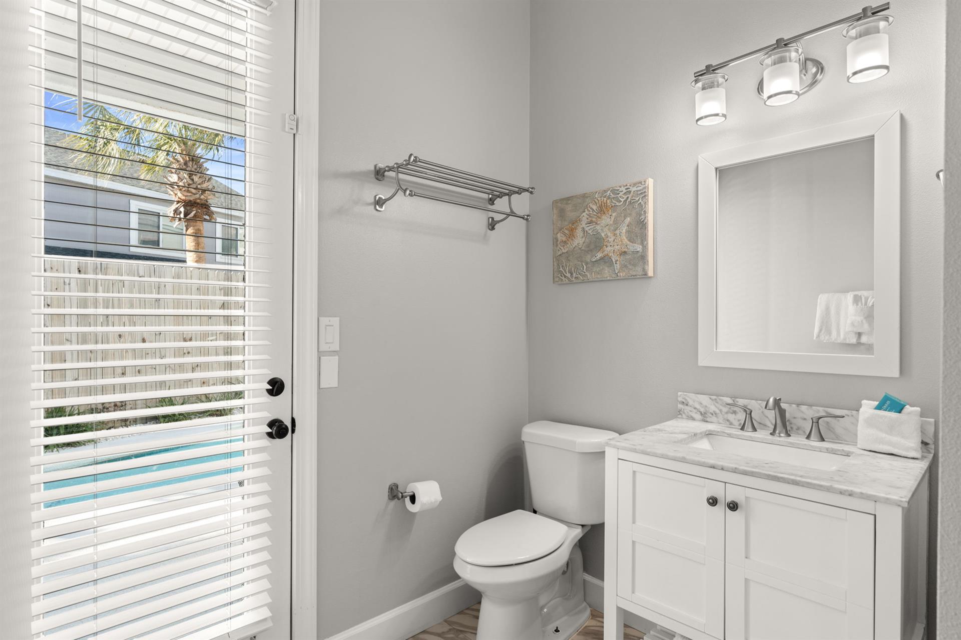 The pristine guest bathroom features marble countertops, modern fixtures, and plenty of natural light to refresh yourself during your stay.