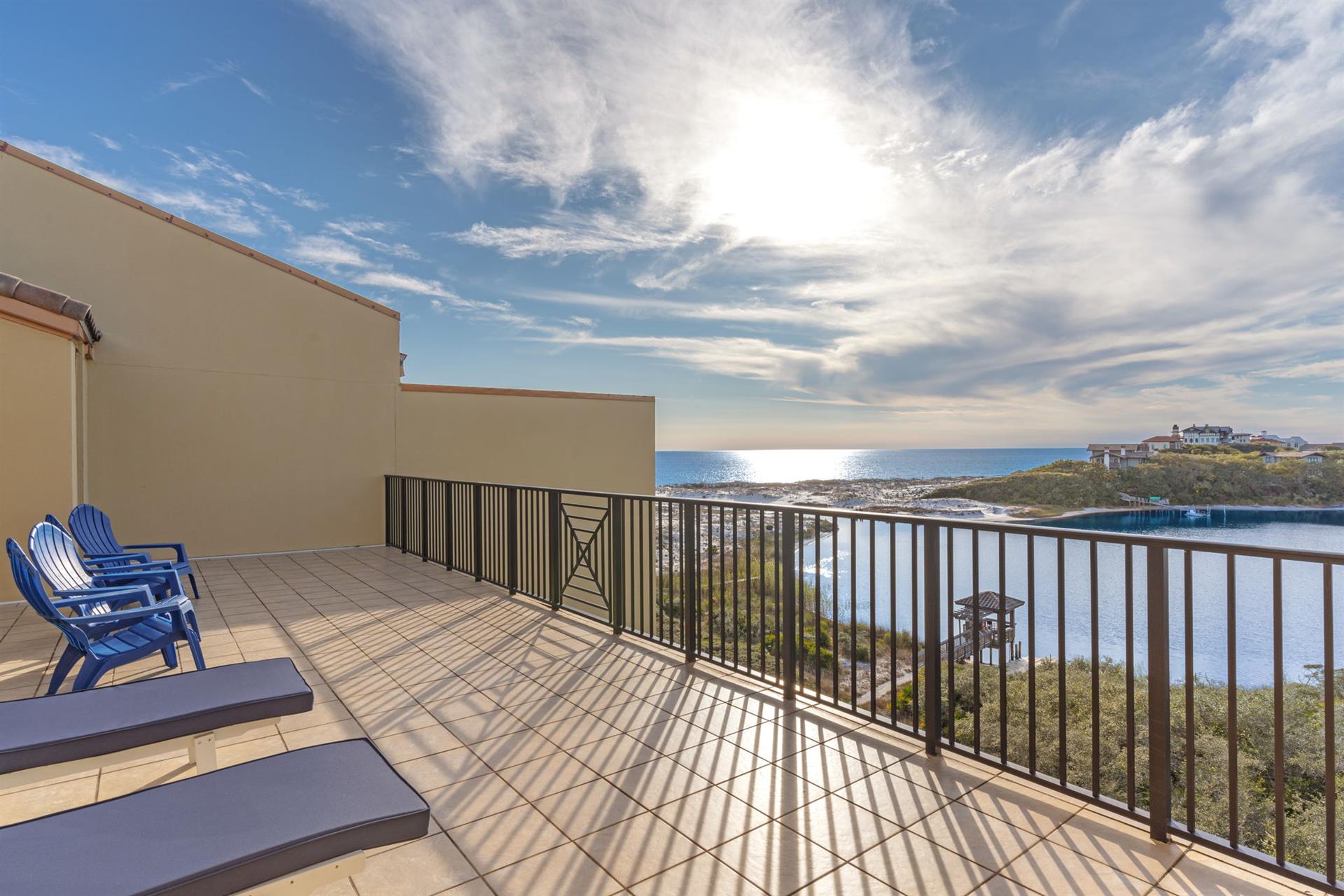 Expansive second floor gulf and lakefront balcony with comfortable seating overlooking pristine waters and natural landscape.