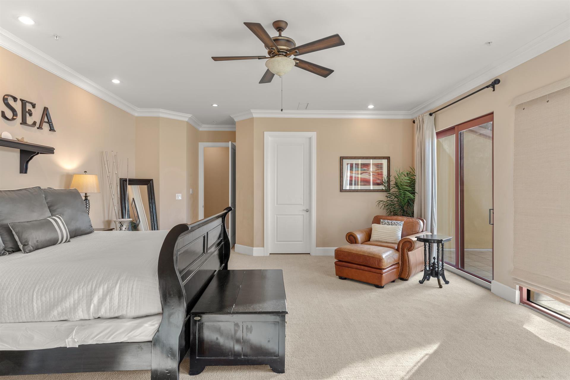 Unwind in your spacious master suite with leather reading chair, ceiling fan, and sliding door to your private outdoor space.