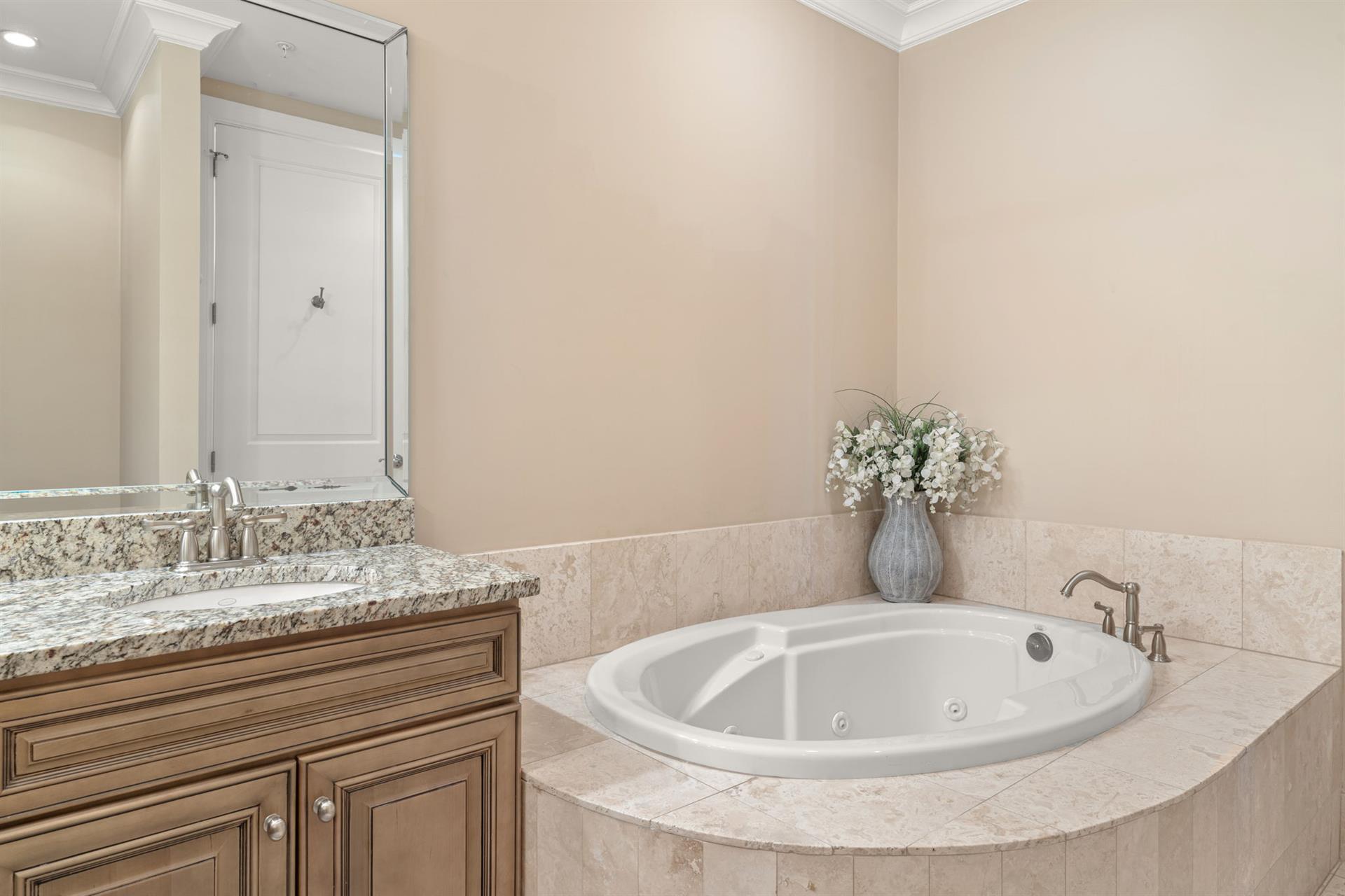 Unwind in your private spalike bathroom with granite countertops, elegant marble details, and a luxurious jetted tub for ultimate relaxation.