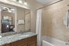 Unwind in your elegant bathroom featuring granite counters, travertine tile, and plush towels for complete relaxation.