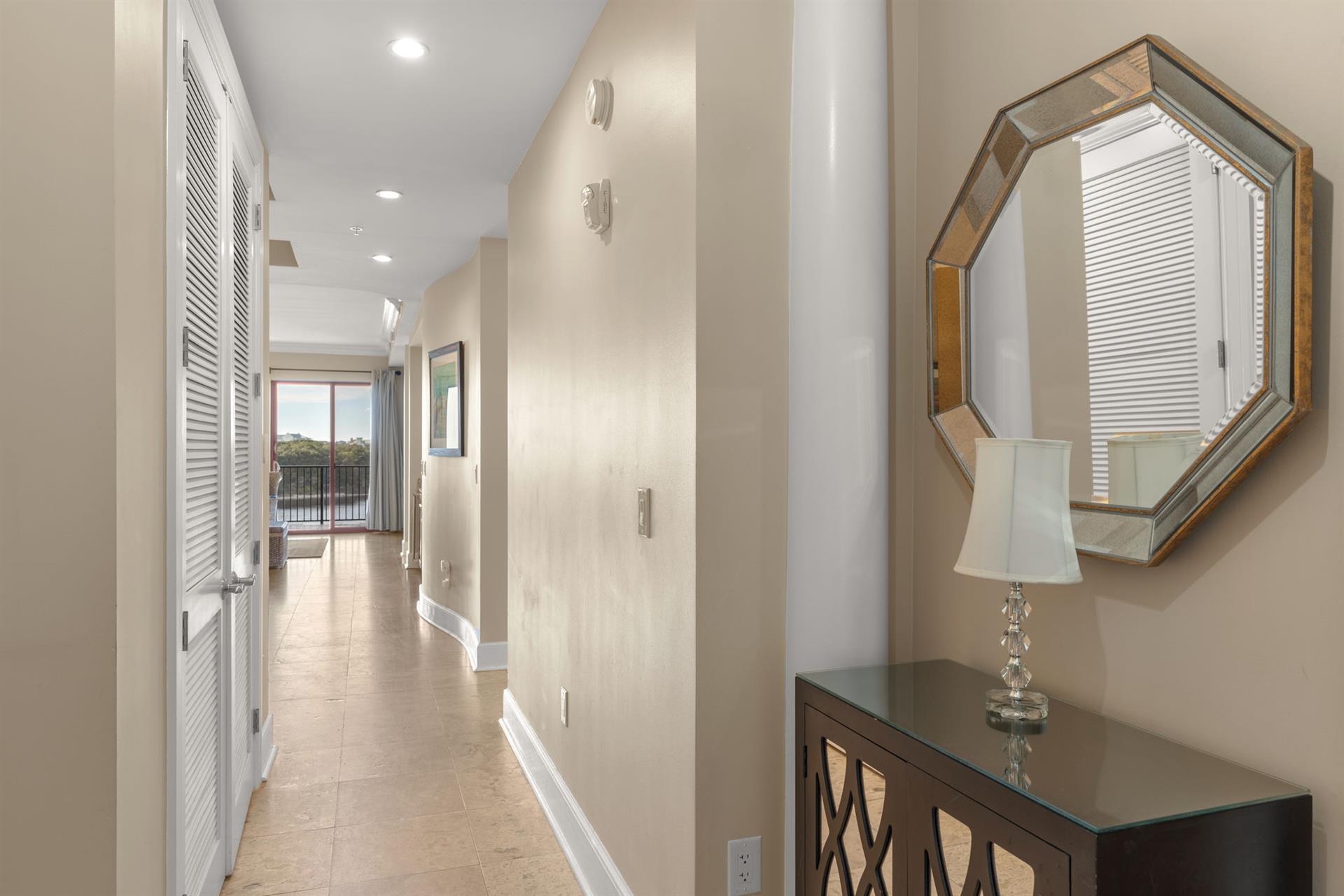 Step into your elegant hallway where natural light floods through, leading you toward your private balcony retreat.