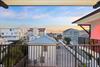 Stunning sunset views of beach houses and coastal architecture from this covered balcony.