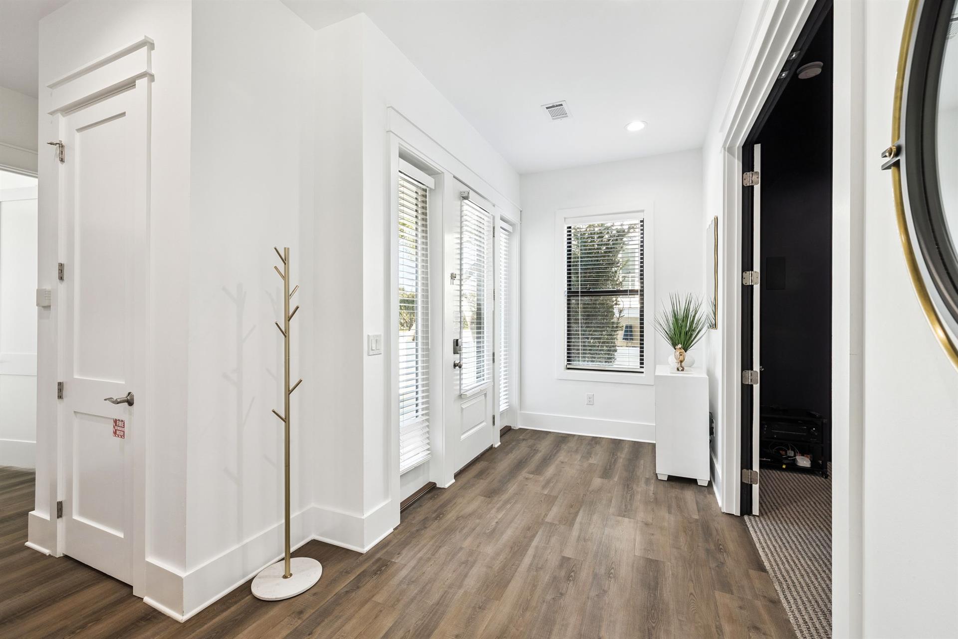 Step into your bright, welcoming entryway where natural light floods through plantation shutters, creating the perfect first impression of your home away from home.