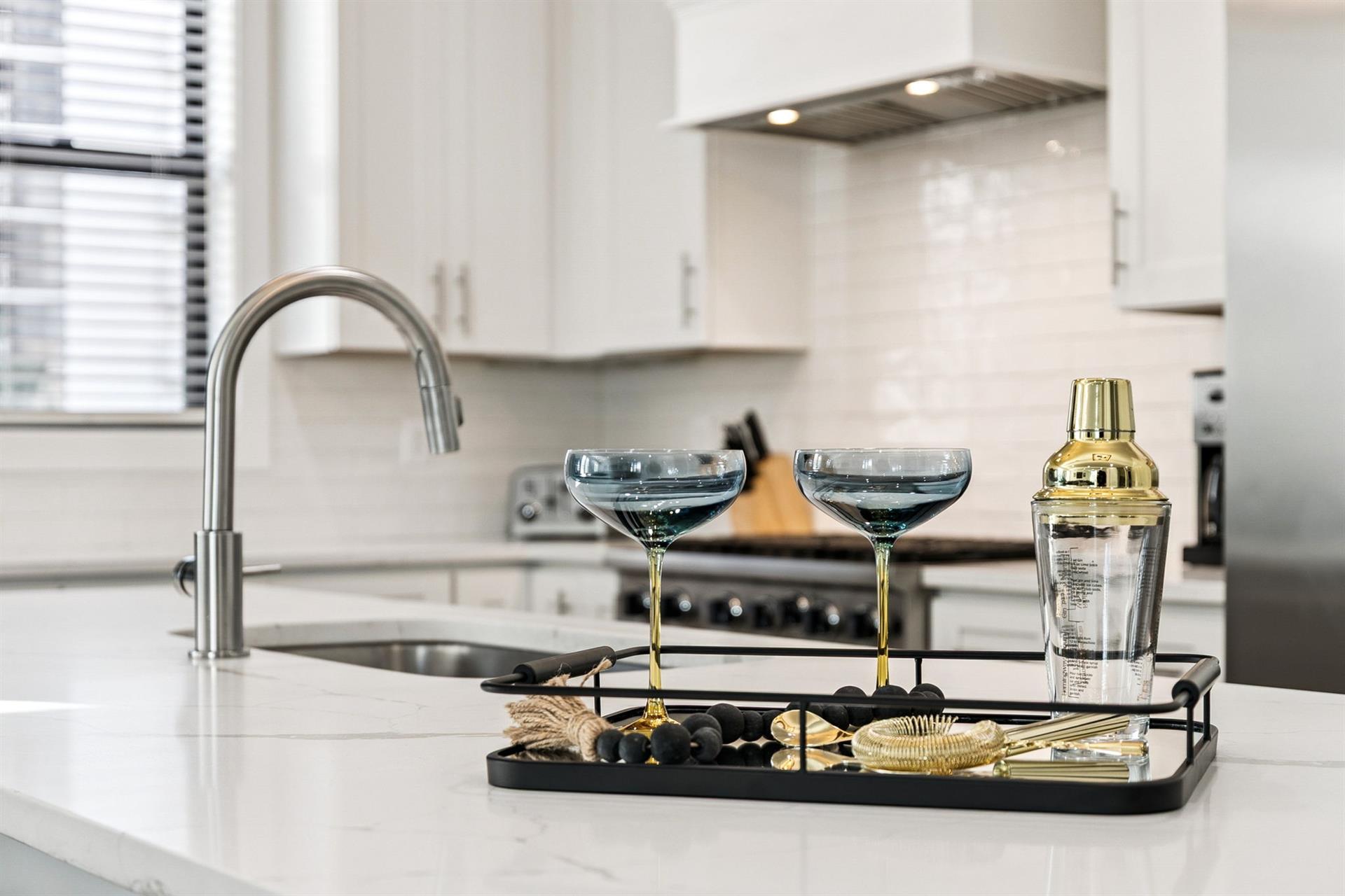 Mix cocktails in the sleek, modern kitchen complete with premium appliances and elegant bar accessories for entertaining.