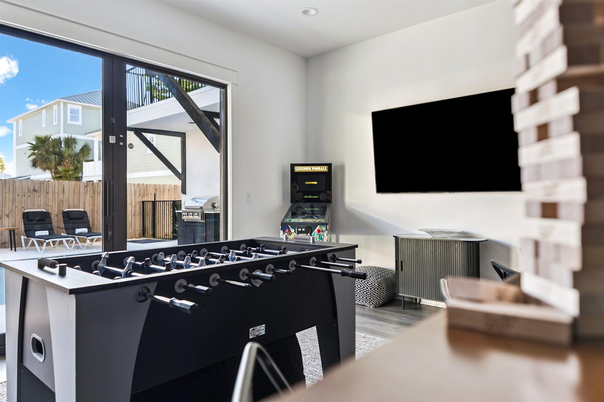Unwind in the entertainment haven with foosball table, arcade games, and flatscreen TV—perfect for friendly competition and relaxing evenings indoors.