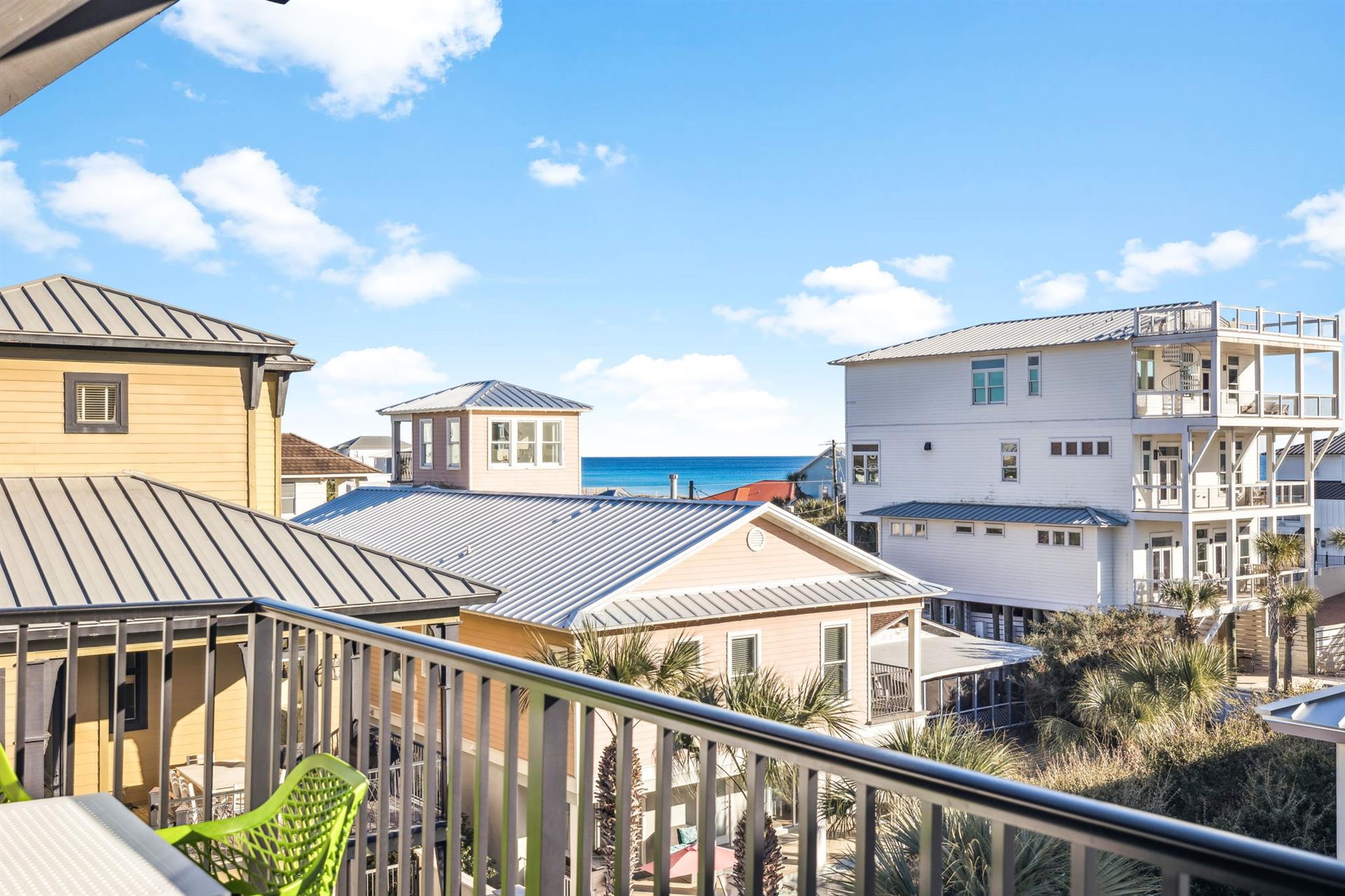 Gulf views peek through the charming coastal architecture from this bright balcony retreat