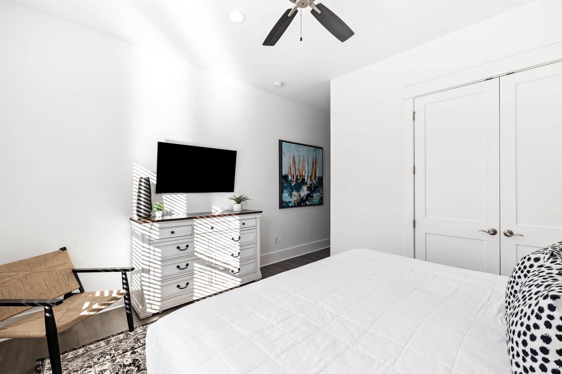 Your bright bedroom features a comfortable bed, flatscreen TV, and stylish furnishings for a restful stay.