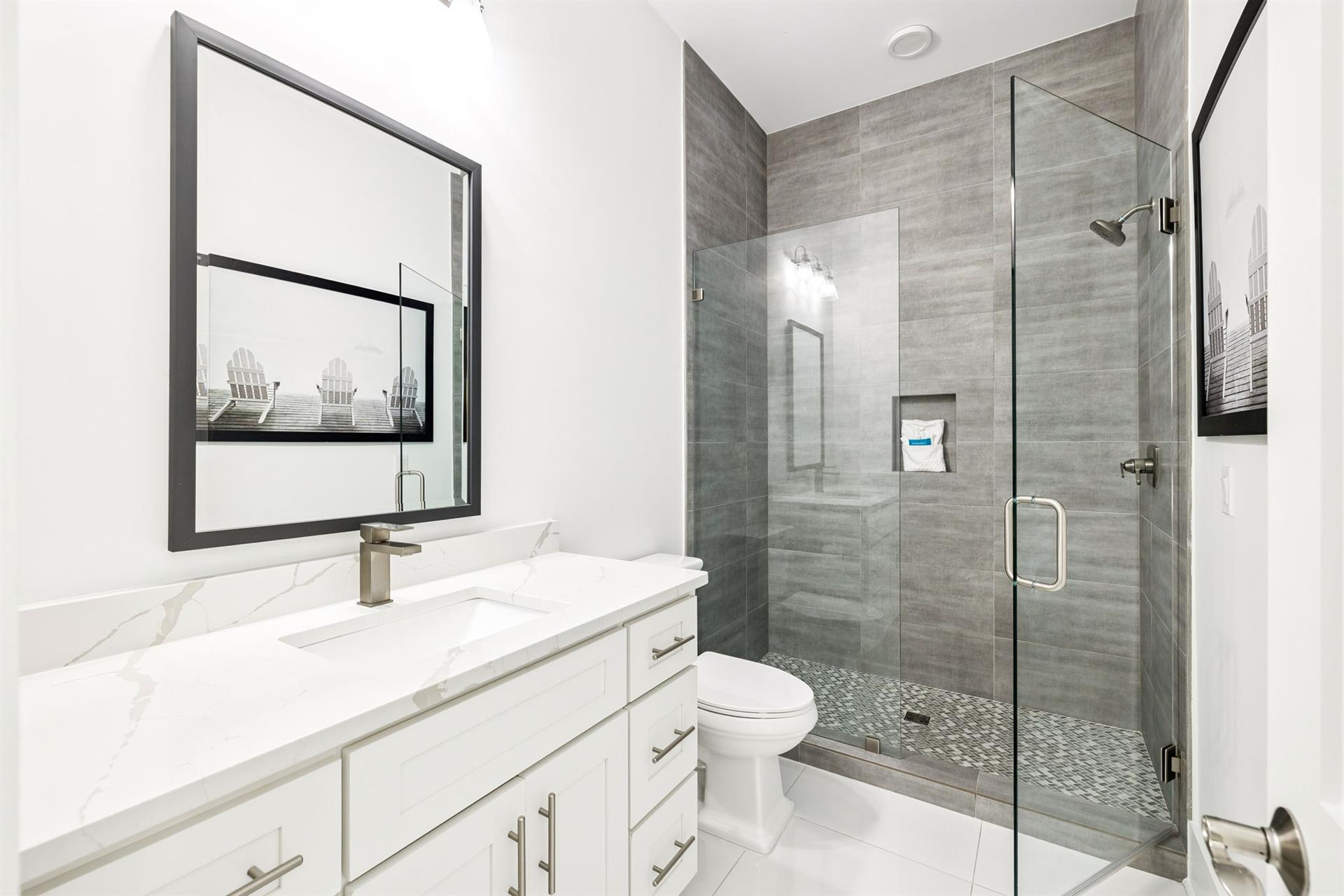 Refresh in your elegant marble bathroom with a spacious glassenclosed shower and pristine white vanity.