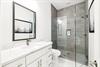 Refresh in your elegant marble bathroom with a spacious glassenclosed shower and pristine white vanity.
