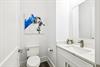 Fresh white powder room with modern vanity and artistic flair for your comfort.