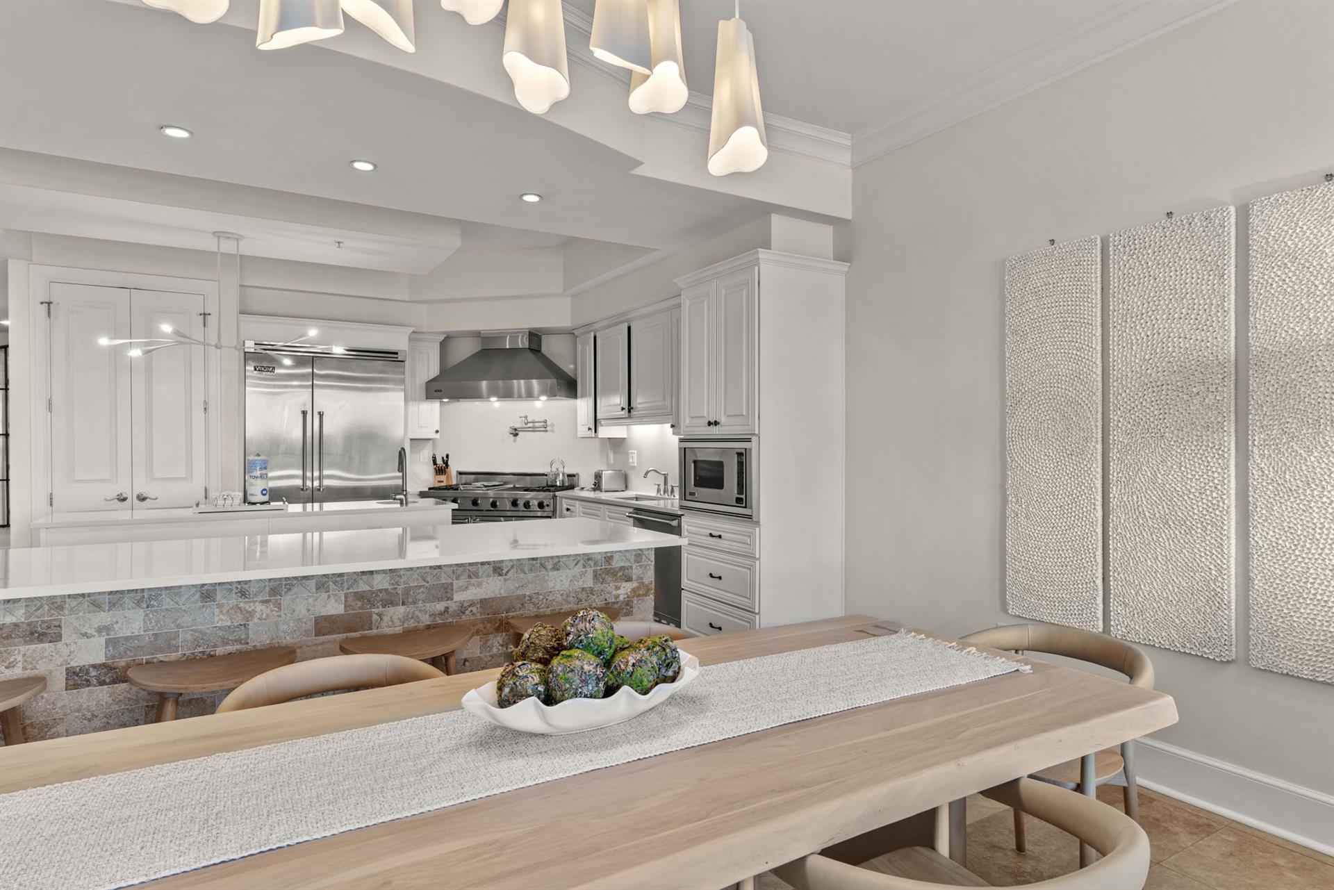 Your spacious gourmet kitchen features premium stainless appliances, elegant white cabinetry, and a stunning island perfect for preparing meals together.