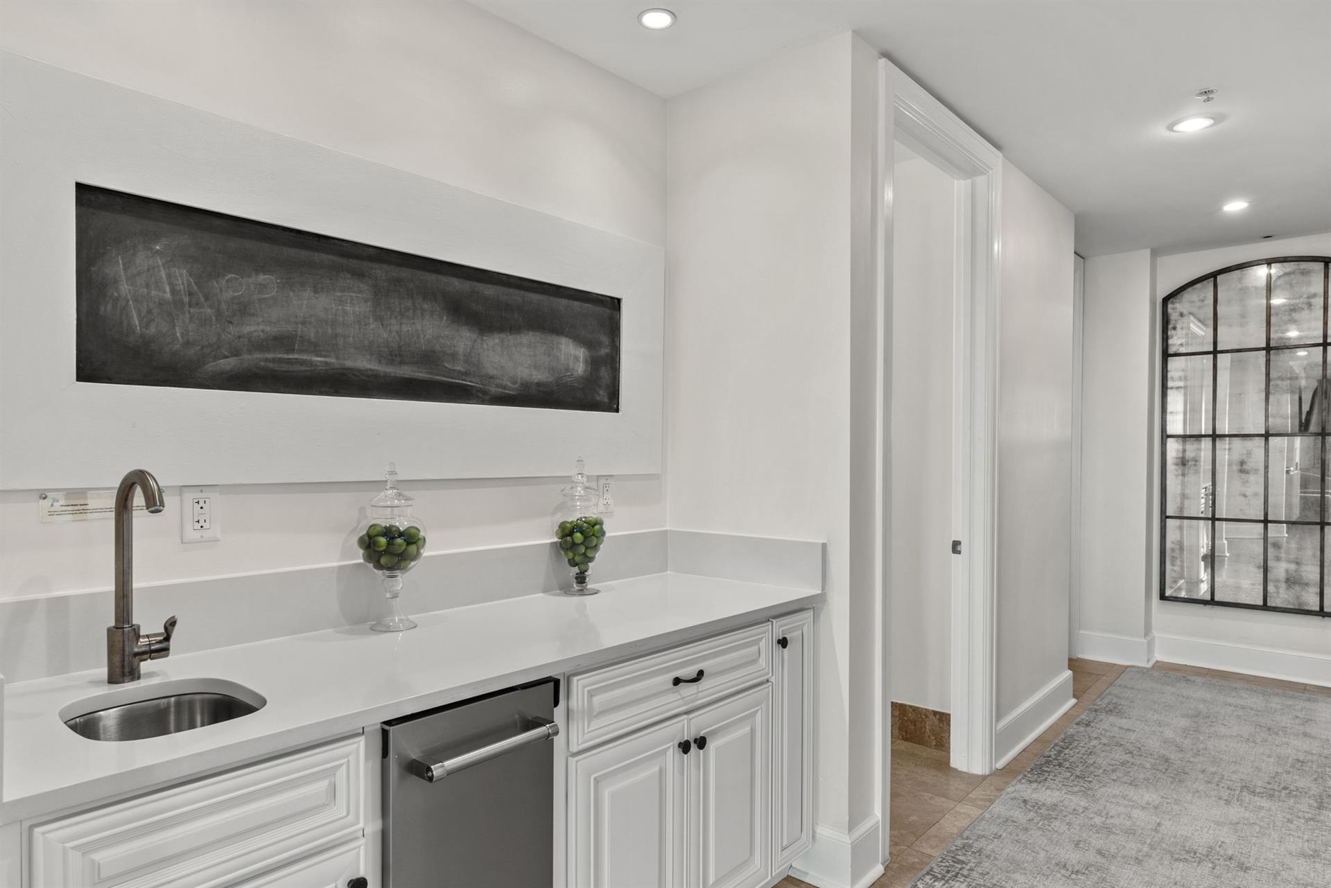 Your elegant kitchenette features pristine white cabinetry, gleaming countertops, and modern appliances for effortless meal prep during your stay.