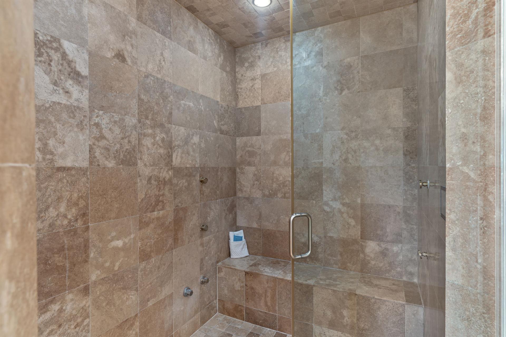 Unwind in your luxurious travertine steam shower, featuring a builtin bench where you can sit and let the warm steam melt away your stress.