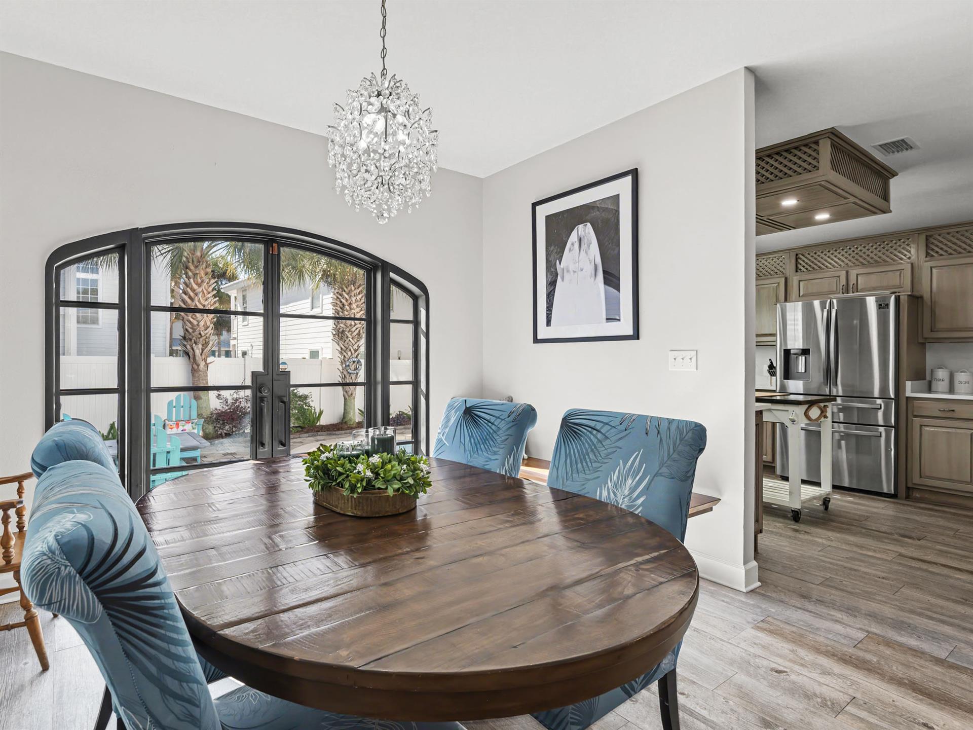 Youll love gathering around this elegant dining table beneath the sparkling chandelier, with natural light streaming through beautiful French doors.
