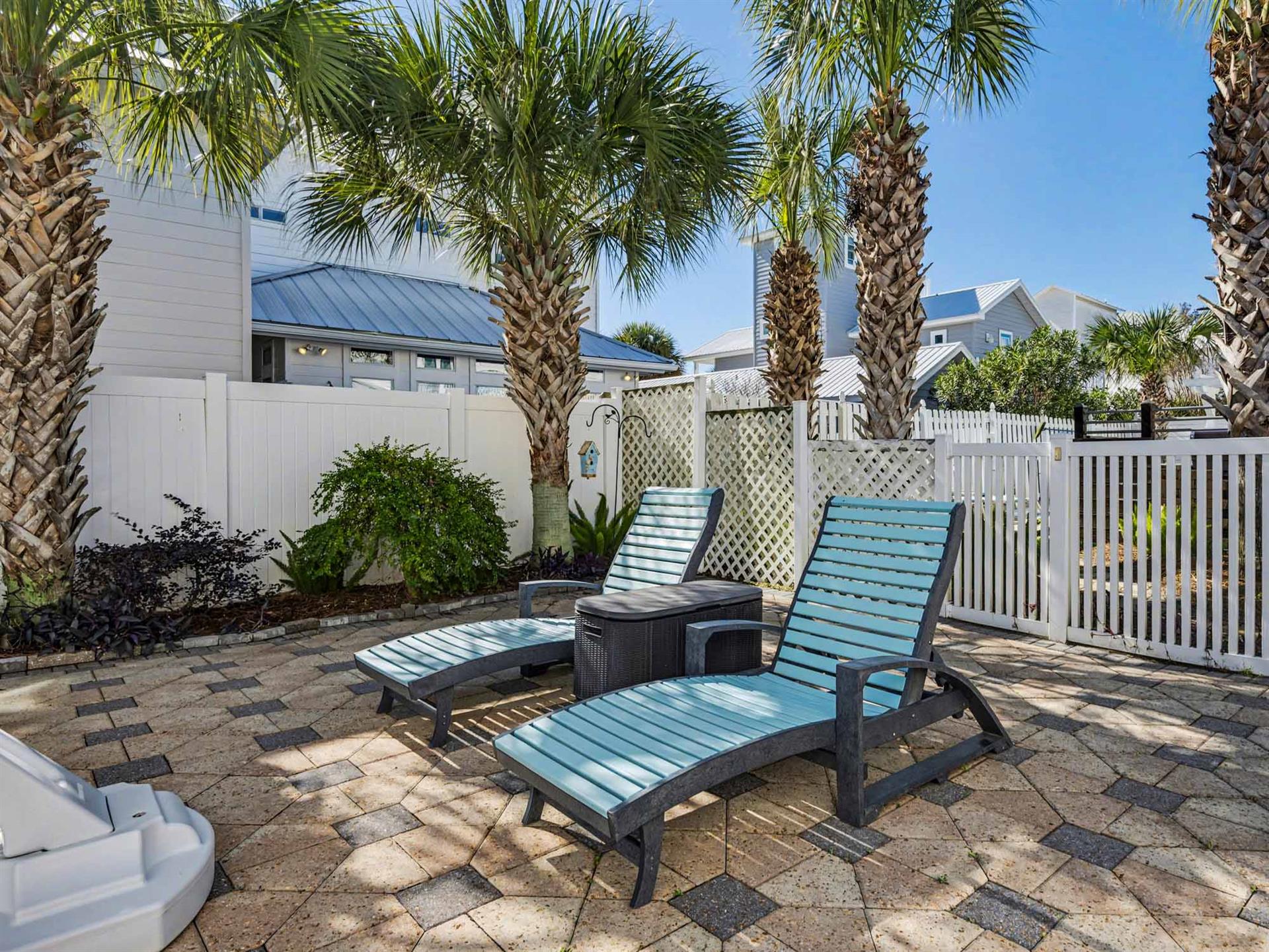 Relax on comfortable lounge chairs surrounded by swaying palms in your private tropical oasis with stylish patio furniture.