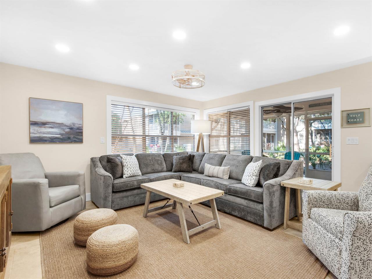 Sink into plush sectional seating where natural light streams through large windows, creating your perfect retreat for morning coffee or evening relaxation.